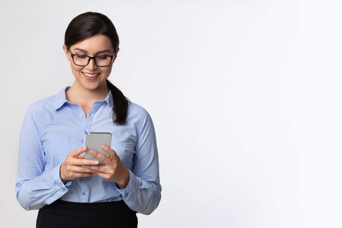 Business Girl Browsing On Smartphone Standing Over White Background